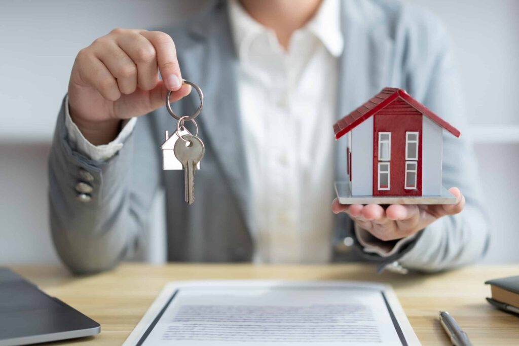 Homme tenant une clé et une maison miniature